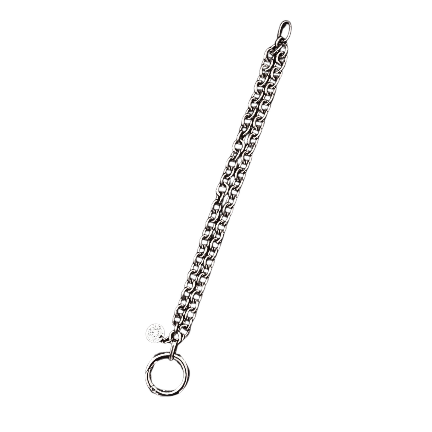 Auf weißem Hintergrund eine doppelt verarbeitete Chunky Chain Armkette von Hug the Lioness aus dunklerem Edelstahl mit einem Ringverschluss. Neben dem Verschluss ist ein kleines Plättchen aus gehämmerten Sterlingsilber angebracht.