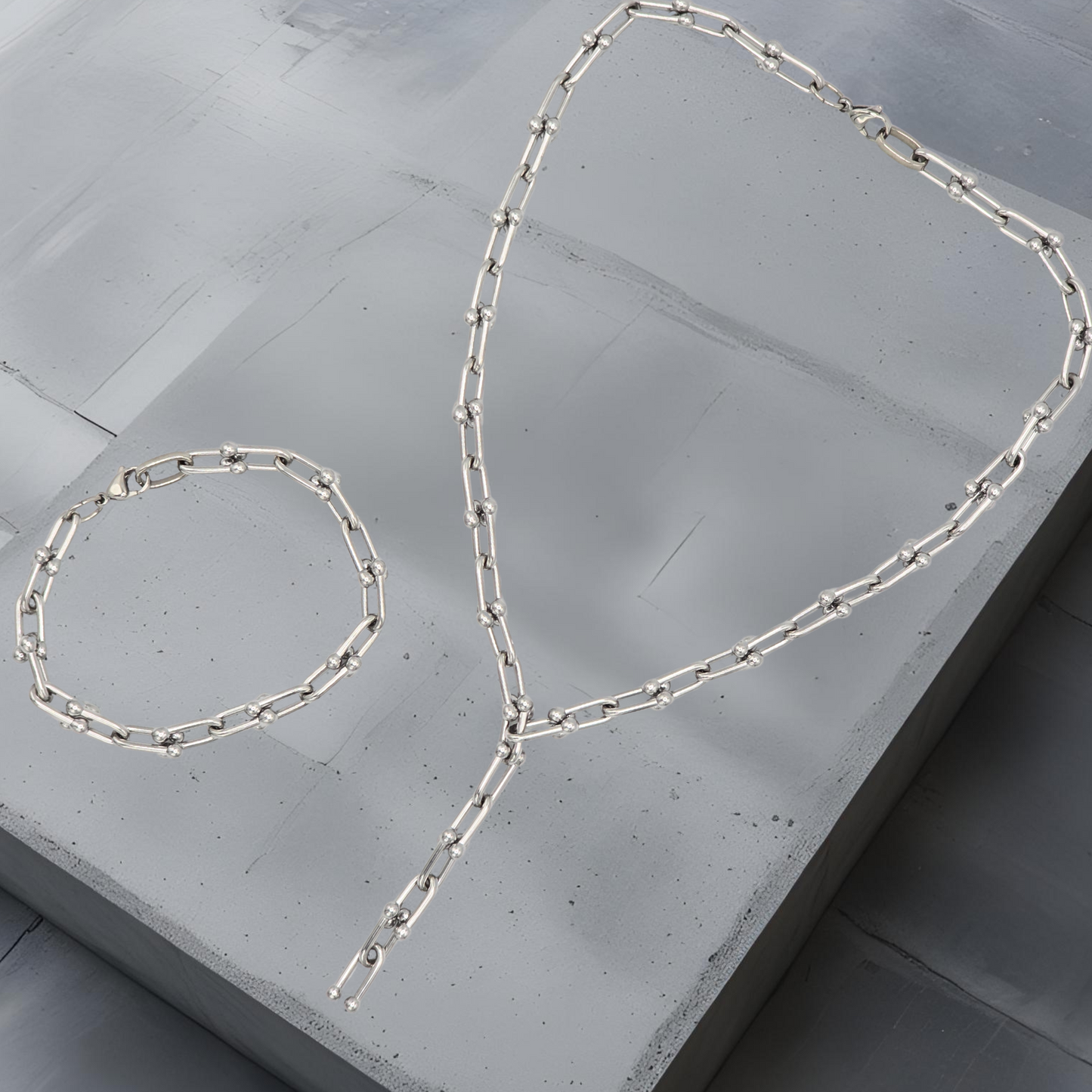 Moderne Y-Kette und Armkette aus Hufeisen-Kettengliedern mit kleinen Kugeldetails. Edelstahlschmuck in minimalistischem Design. Kette und Armkette haben ein klares puristisches Design. Länge 43cm mit Y-Anhängerteil. Armkette 19cm. Die Abbildung des Sets dient nur der Veranschaulichung, der Preis bezieht sich auf die Halskette.