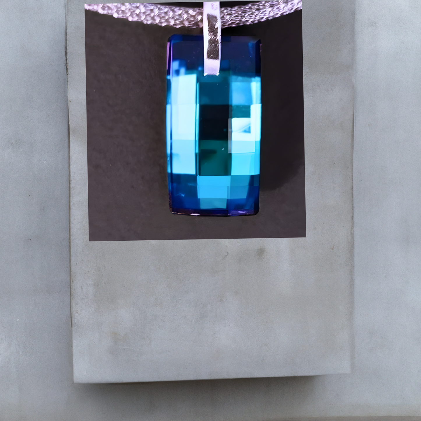 Collier von der Schmuckmarke Hug the Lioness. Silberfarbene Meshkette aus Edelstahl mit einem rechteckigen Anhänger aus Kristall Bermuda Blue 28mm