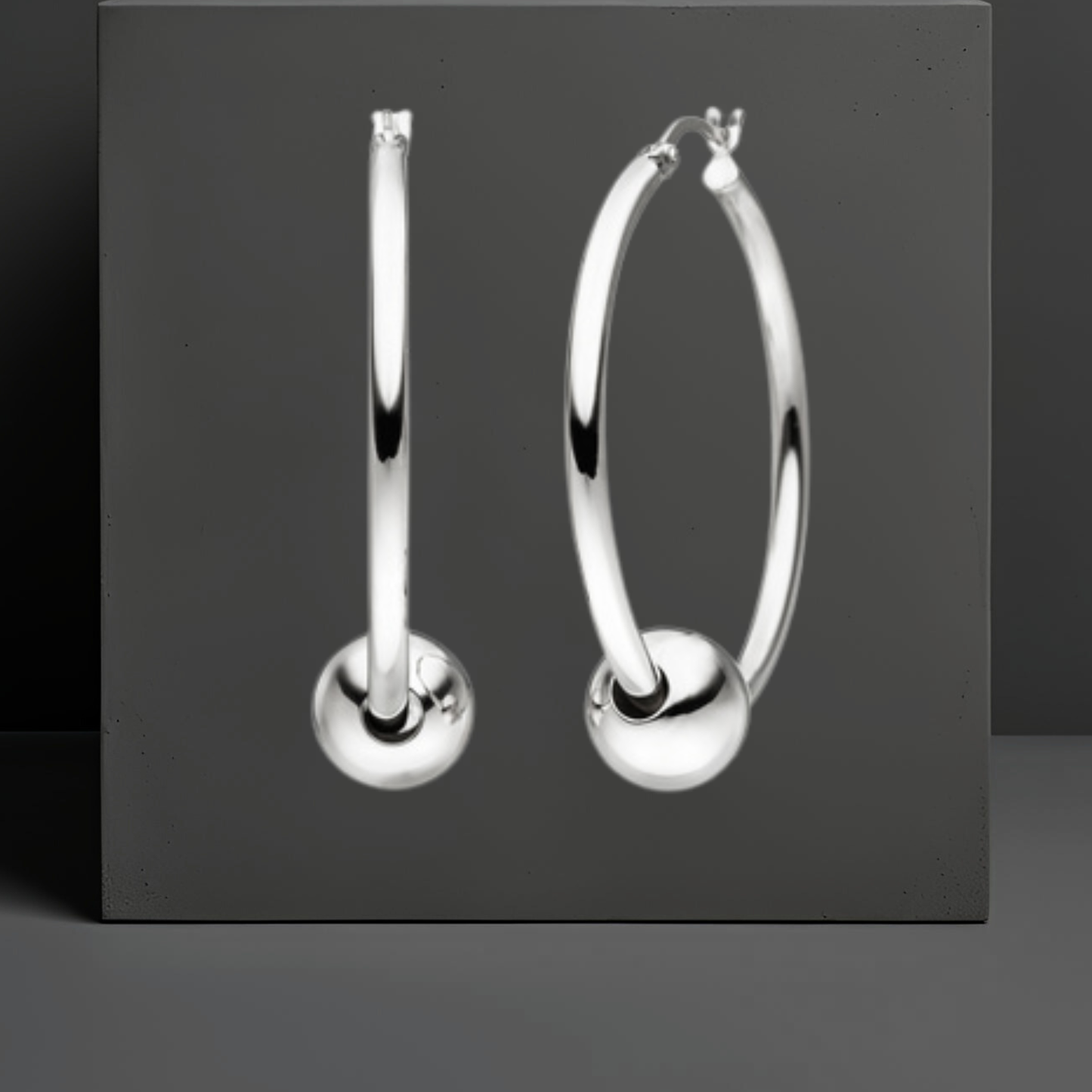 Stylisher Ohrschmuck von Hug the Lioness. Die glatten Creolen aus Sterlingsilber haben einen Durchmesser von 36,5 mm und eine Stärke ca. 2,4 mm. Die Ohrringe sind jeweils durch eine glatte silberne Kugel von 10mm gezogen. Hebelverschluss.