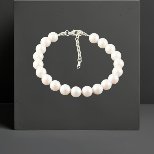 Damen Armband aus weißen schimmernden  Kristallperlen, alle 8mm gross. Mit  Karabinerverschluss und Verlängerungskette von 3cm aus 925 Sterlingsilber. Schmuckmarke Hug the Lioness aus Österreich.