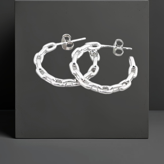 Die feingliedrigen und leichten Creolen mit Steckverschluss sind aus Sterlingsilber, rhodiniert und anlaufgeschützt. Ohrschmuck der Marke Hug the Lioness aus Österreich. Die Creolen haben das Muster einer Ankerkette und die Maße 23mmx3mm.