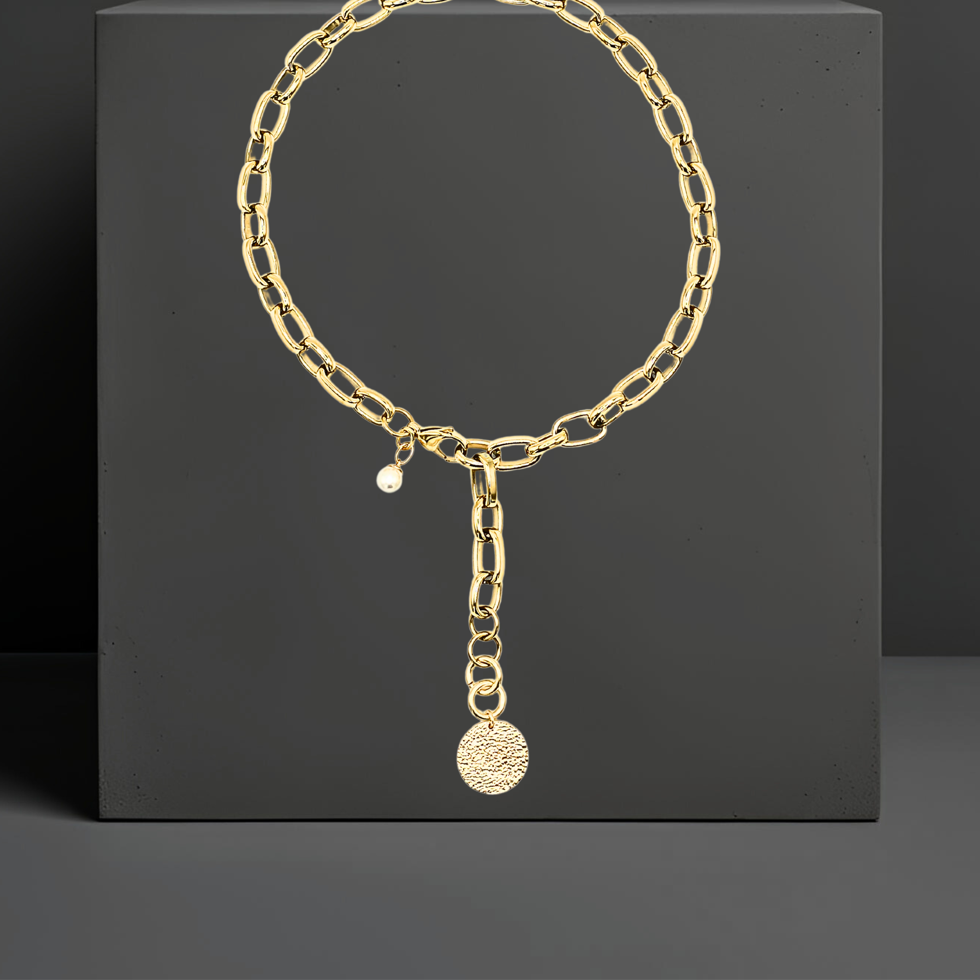 Exklusive goldfarbene Y-Halskette aus PVD beschichtetem Edelstahl. Mit einem Anhänger aus gehämmerten Sterlingsilber und einer Perle. Eleganter auffälliger Statementschmuck von der österreichischen Schmuckarke Hug the Lioness in Wattens, Tirol.