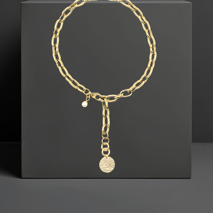 Exklusive goldfarbene Y-Halskette aus PVD beschichtetem Edelstahl. Mit einem Anhänger aus gehämmerten Sterlingsilber und einer Perle. Eleganter auffälliger Statementschmuck von der österreichischen Schmuckarke Hug the Lioness in Wattens, Tirol.