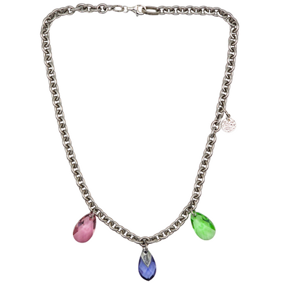 Collier aus Edelstahl, silberfarbene Gliederkette vorne mit 3 Kristalltropfen in rose, violett und grün. Die Kette ist 43cm lang und hat einen Karabinerverschluss. An der Seite ist in kleines gehämmertes Plättchen aus 925 Sterlingsilber angebracht. Die Kette ist aus der Kollektion JOY der Schmuckmarke HUG THE LIONESS.