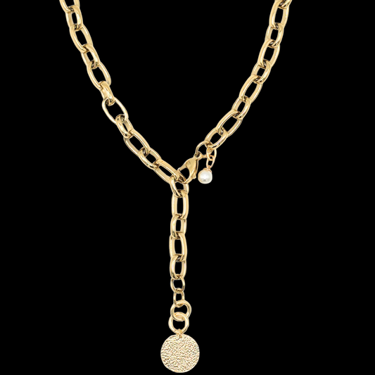 Exklusive goldfarbene Y-Halskette 47cm aus PVD beschichtetem Edelstahl. Die Kettenglieder sind breit und glänzend. Die Halskette hat einen vergoldeten 20mm Anhänger aus gehämmerten Sterlingsilber in Form einer Münze. Die 9mm breite Kette hat einen Karabinerverschluss der vorne flexibel zu schließen ist. Neben dem Karabiner ist eine 8mm Perle befestigt. Edelstahlschmucke von der Schmuckmarke Hug the Lioness aus Österreich. 
