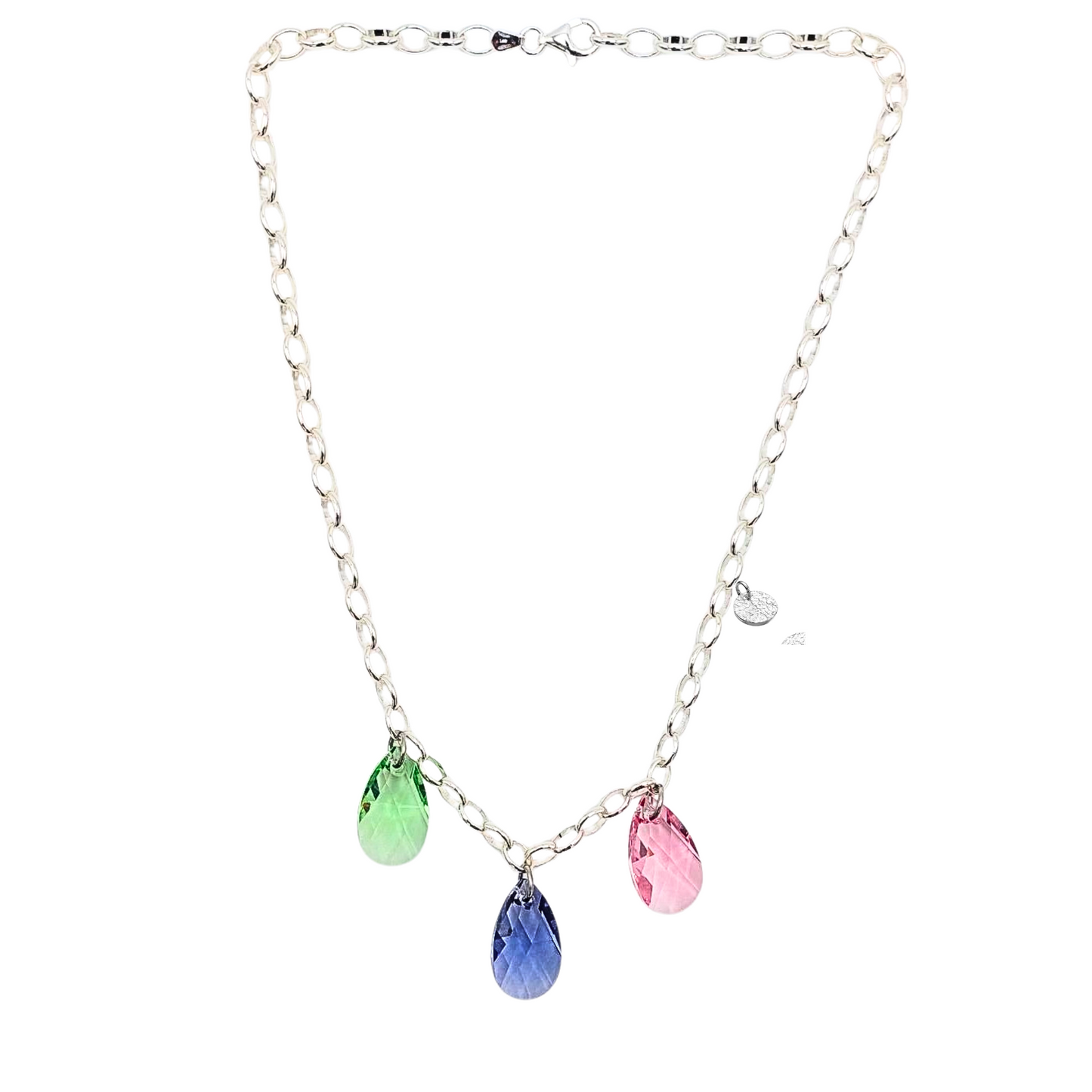 Collier aus 925 Sterlingsilber,  Gliederkette vorne mit 3 Kristalltropfen in rose, violett und grün. Die Kristalle sind aus Österreich. Die Kette ist 42cm lang und hat einen Karabinerverschluss. An der Seite ist in kleines gehämmertes Plättchen aus 925 Sterlingsilber angebracht. Die Kette ist aus der Kollektion JOY der Schmuckmarke HUG THE LIONESS.