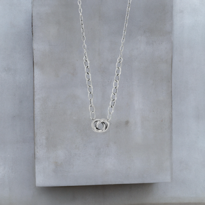 Kurze Halskette 40cm aus platiniertem Sterlingsilber und Verlängerungskette mit 9mm kleinen verschlungenen Ringen an der Vorderseite. Die Halskette ist von der Schmuckmarke Hug the Lioness. Der vordere Teil der Halskette hat 5mm große Kettenglieder, der hintere Teil hat 2mm kleine Kettenglieder.