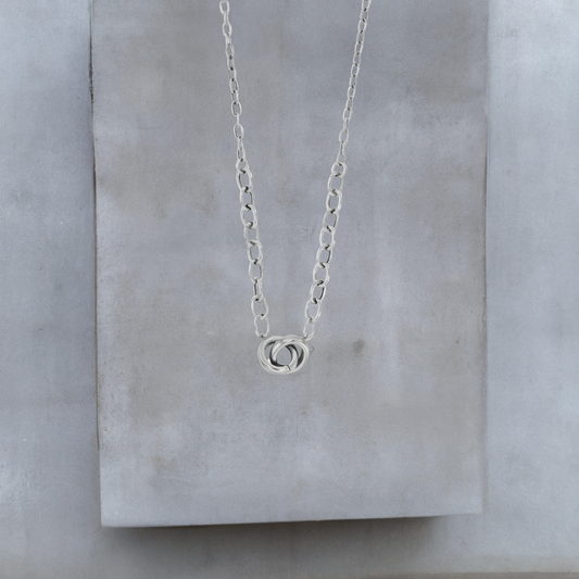 Kurze Halskette 40cm aus platiniertem Sterlingsilber und Verlängerungskette mit 9mm kleinen verschlungenen Ringen an der Vorderseite. Die Halskette ist von der Schmuckmarke Hug the Lioness. Der vordere Teil der Halskette hat 5mm große Kettenglieder, der hintere Teil hat 2mm kleine Kettenglieder.