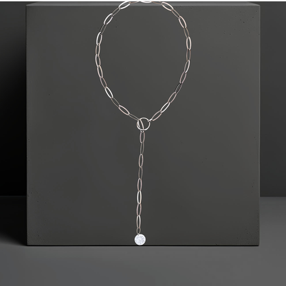 Lange Y-Lassokette aus hellem Edelstahl im Lariat Style. Das Kettenende mit dem gehämmerten Silberanhänger wird einfach durch den angebrachten Ring gezogen. Die Halskette ist 80cm lang und hat 7mm breite längliche Kettenglieder. Handgefertigt von Hug the Lioness in Tirol, Österreich.