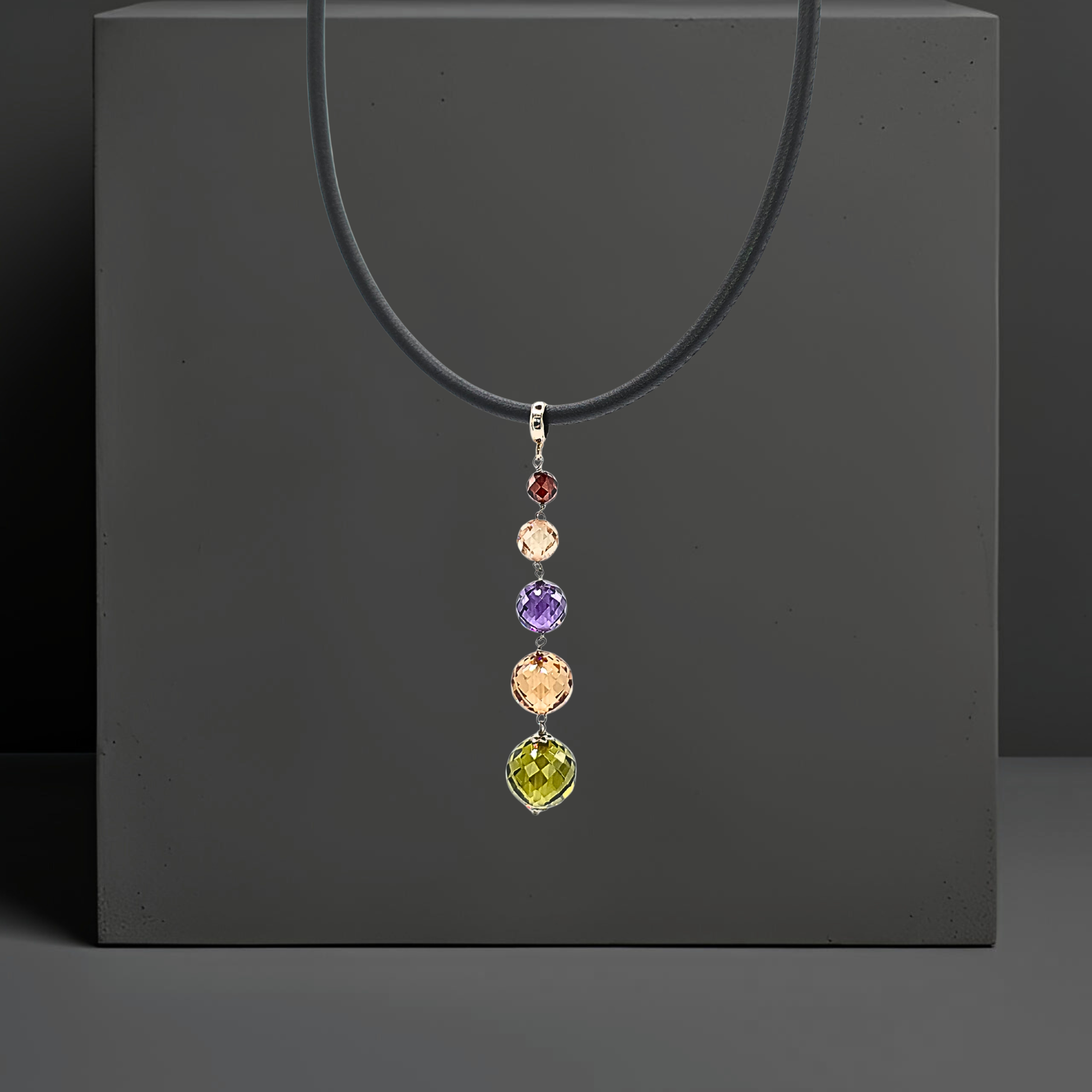 Set mit bunten Zirkonen handgefertigt:  Lederkette und Ohrclipsen mit Anhänger aus farbigen Zirkonen. Anhänger und Ohrringe sind 75mm lang und bestehen jeweils aus 5 leuchtenden, facettierten Zirkonkugeln in grün, goldgelb, violett, rose und rot    in abgestufter Größe. Der Schmuck ist von der Marke Hug the Lioness.