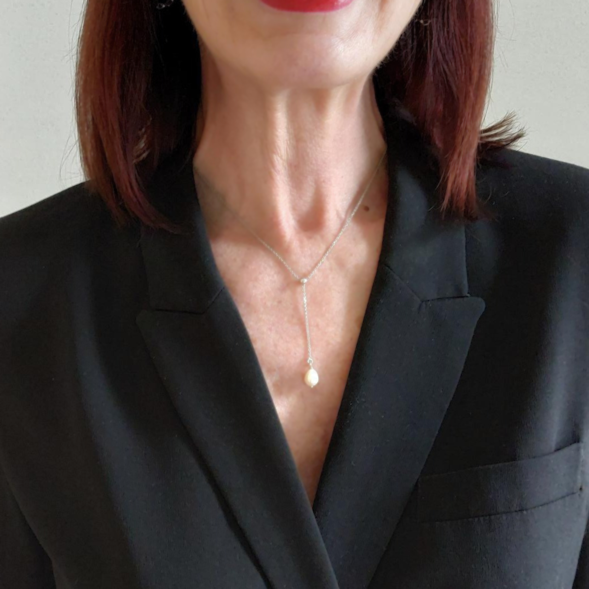 Model mit sehr feiner Y-Kette aus 925 Sterlingsilber 42 cm . Anhänger ist eine 9mm Süsswasserperle. Die Halskette ist Silberschmuck der Marke Hug the Lioness aus Österreich. Die Kette hat einen Federringverschluss. 