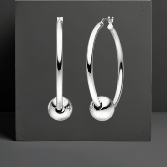 Stylisher Ohrschmuck von Hug the Lioness. Die glatten Creolen aus Sterlingsilber haben einen Durchmesser von 36,5 mm und eine Stärke ca. 2,4 mm. Die Ohrringe sind jeweils durch eine glatte silberne Kugel von 10mm gezogen. Hebelverschluss.