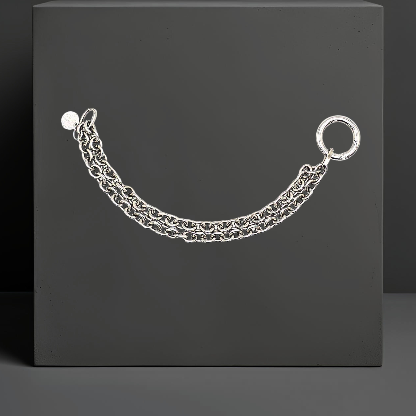 Doppelt verarbeitete Chunky Chain Armkette für Frauen von Hug the Lioness. Handgefertigt in Wattens, Österreich aus dunklerem Edelstahl mit einem Ringverschluss. Neben dem Verschluss ist ein kleines Plättchen aus gehämmerten Sterlingsilber angebracht.