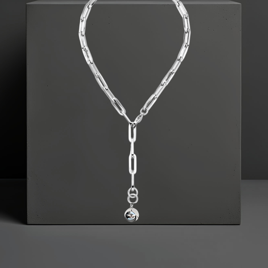 Klassisch moderne Y-Halskette aus Edelstahl mit breiten Kettengliedern in 55cm. Am Ende der Kette ist eine glänzende glatte Kugel von 20mm als Anhänger angebracht. Der Karabinerverschluss ist vorne flexibel zu schließen. Handgefertigt von Hug the Lioness Schmuck aus Wattens, Österreich. 