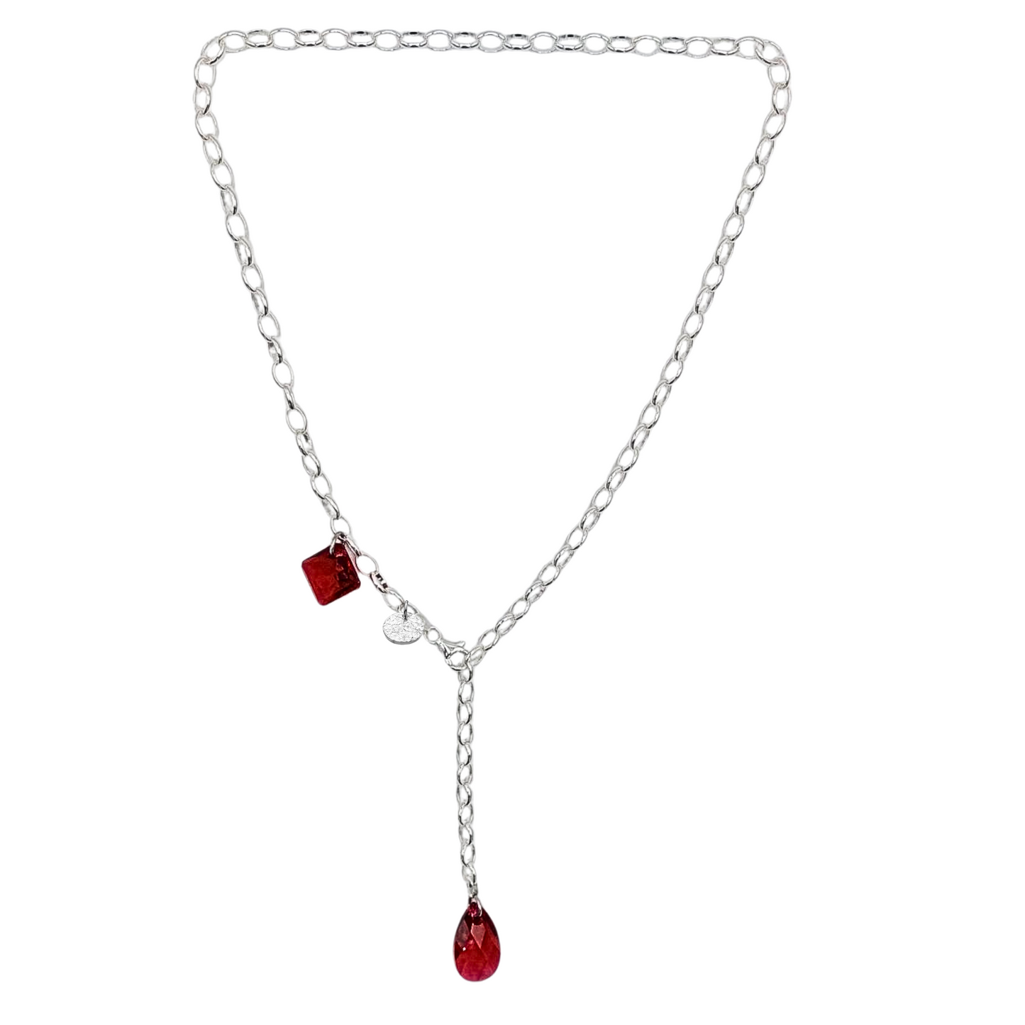 Trendige Y-Kette, Kristallkette mit 2 roten Kristallen aus 925 Sterlingsilber. Der Stil ist modern und elegant. Die Kette ist vorne zu schließen und die Länge ist variabel. Die Silberkette ist 50cm lang, am Ende ist ein roter Kristalltropfen angebracht, an der Seite ein viereckiger roter Kristall und ein gehämmertes Silberplättchen. 