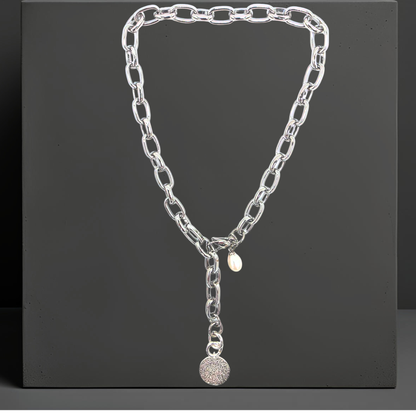 Exklusive Edelstahl Halskette für Damen von der Schmuckmarke Hug the Lioness aus Österreich.
Elegante breite Statement Y-Halskette 47cm aus 316L Edelstahl in silber. Die Halskette hat einen  Anhänger aus gehämmerten Sterlingsilber in Form einer Münze. und eine Perle. Der Karabinerverschluss ist vorne flexibel zu schließen. 